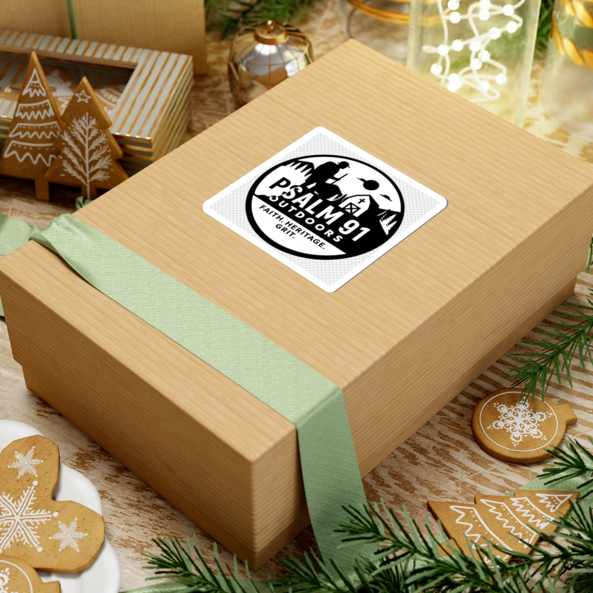 Gift box with a green ribbon and a label on a festive background with cookies and decorations.